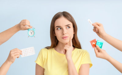 young woman and hands with different means of contraception